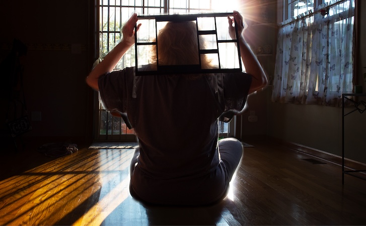 A person holding a window frame over their head